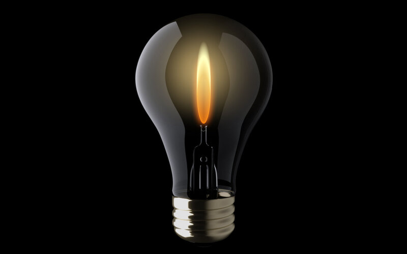 lit light bulb on black