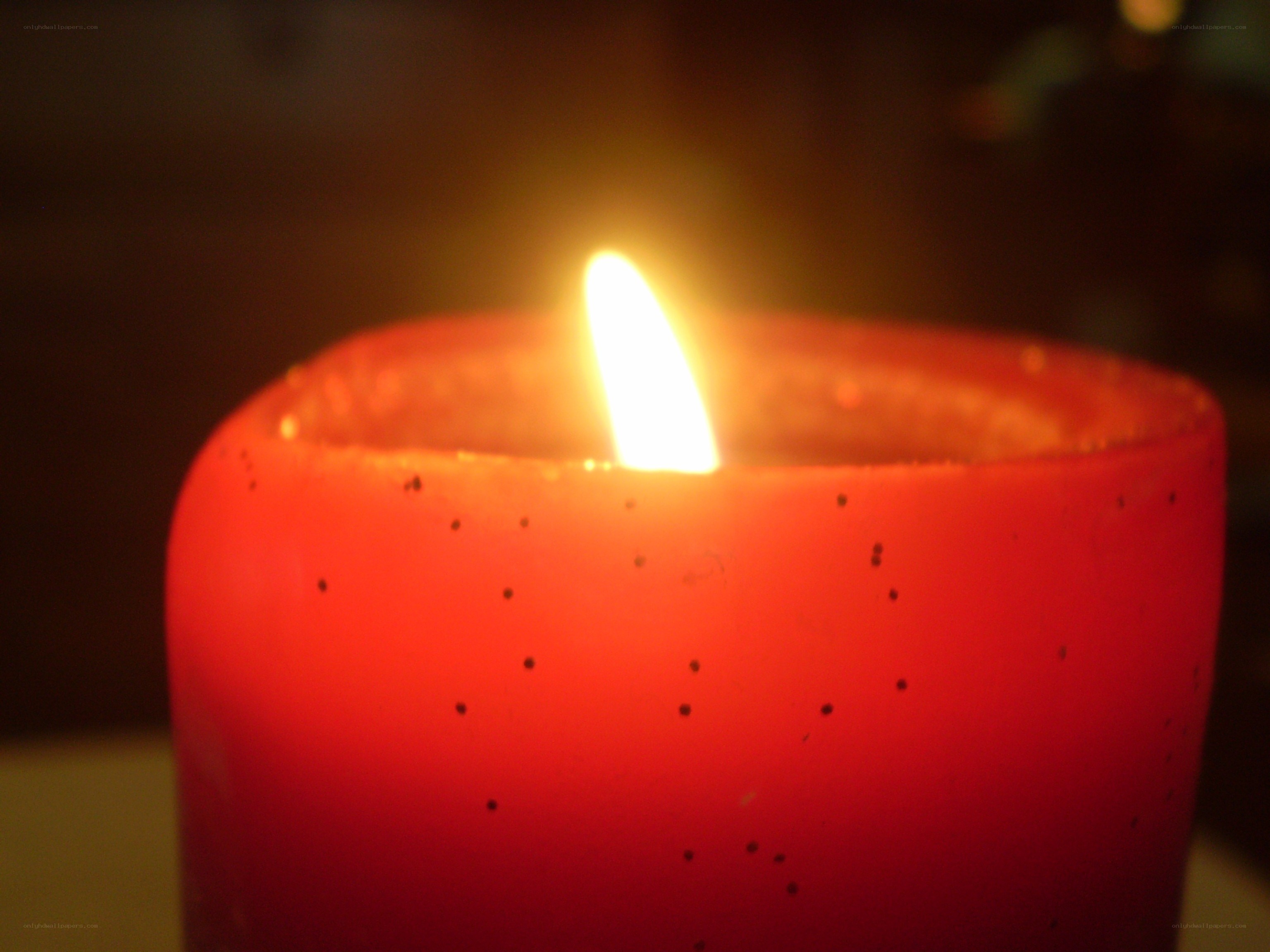 lit red candle in darkness
