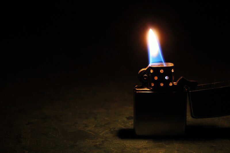 Lit Zippo Lighter — Black, Dramatic