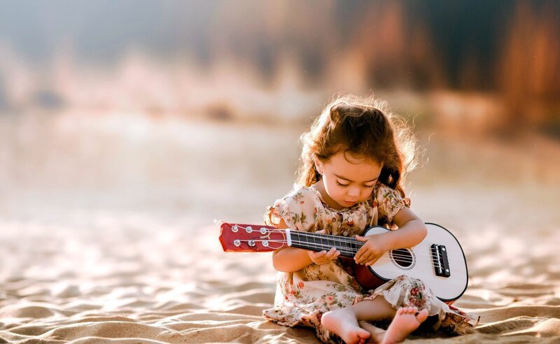 Little Girl Playing Ukulele — Beige