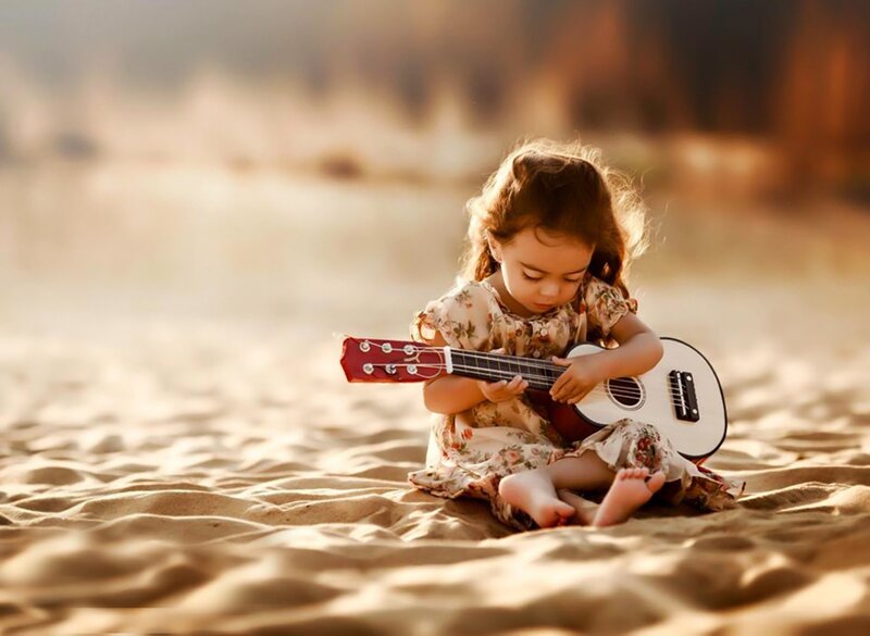 Little Girl Playing Ukulele — Brown, Serene