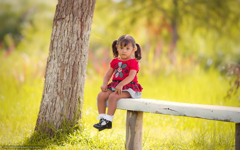 Little girl sitting on a bench