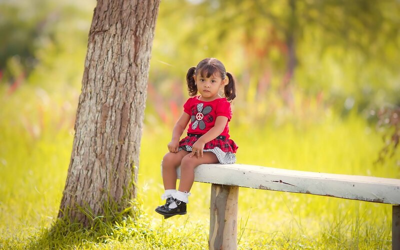 Little girl sitting on a bench