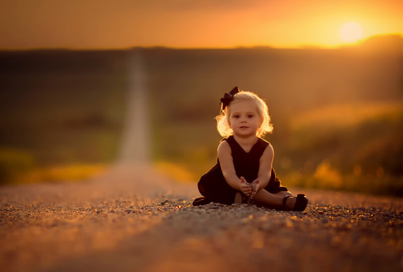 Little Girl Sitting on Road
