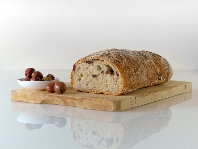 Loaf of olive bread on cutting board
