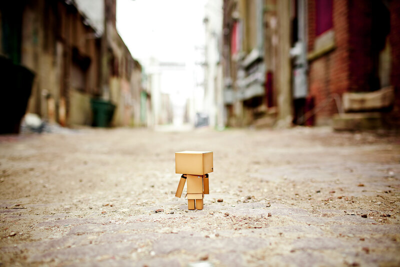 lonely cardboard figure in alley