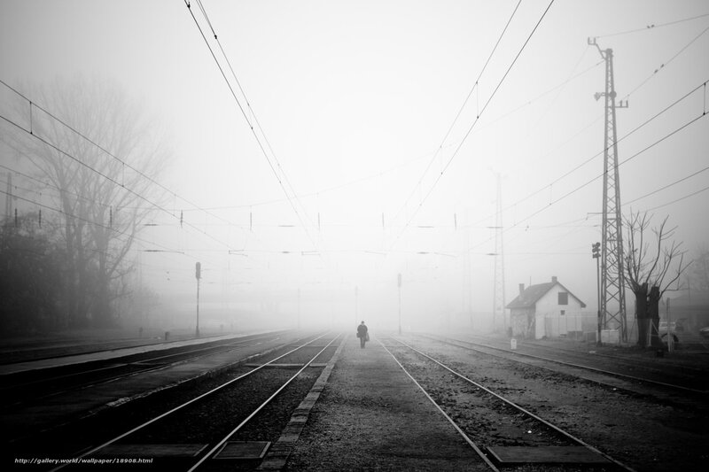 Lonely figure on foggy train tracks