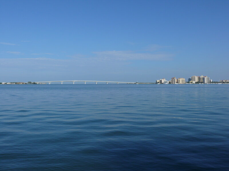 Long Bridge over Water — Blue, Serene, Afternoon, Photograph, City Skyline