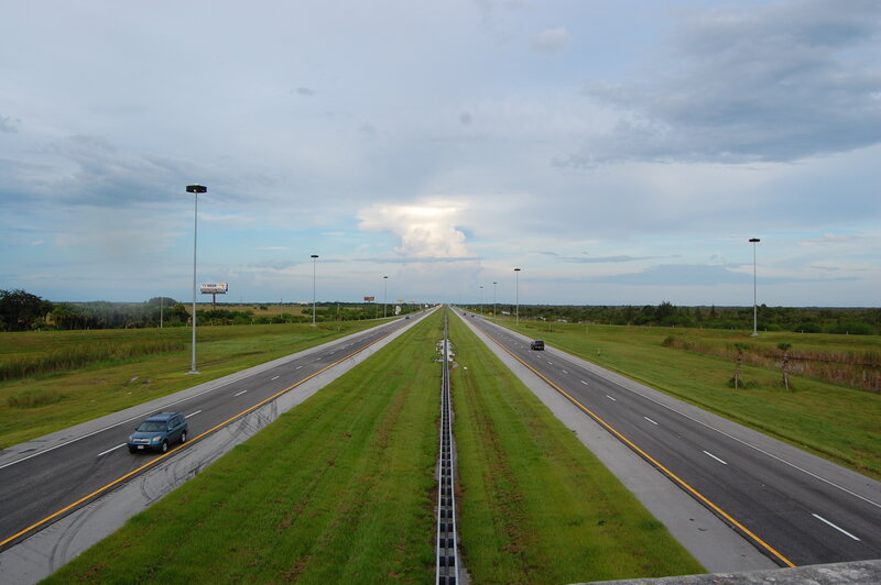 Long highway stretch under cloudy sky