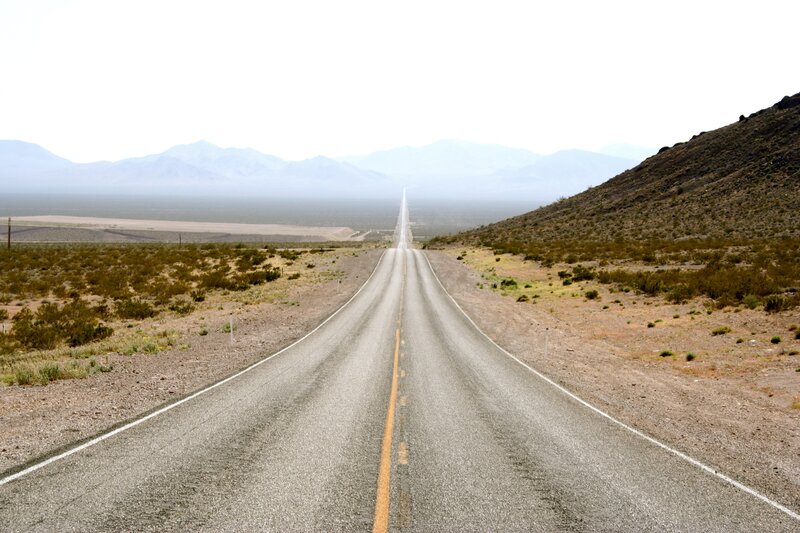 Long Road in Desert — Gray, Desolate, Afternoon, Photograph, Mountains, Bushes