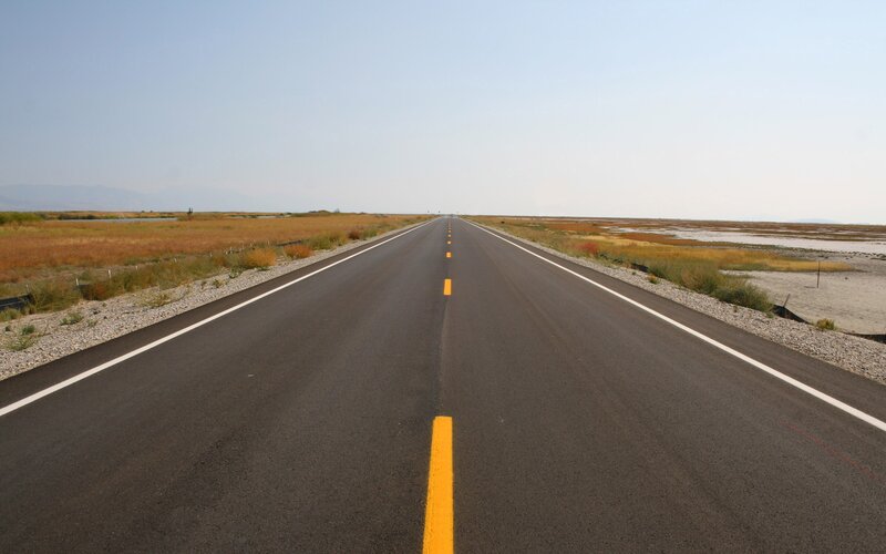 Long road through a flat landscape