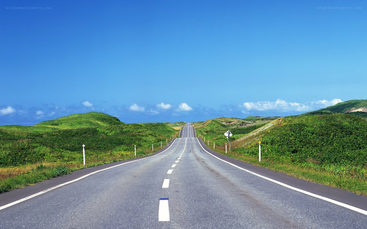 Long road through green hills