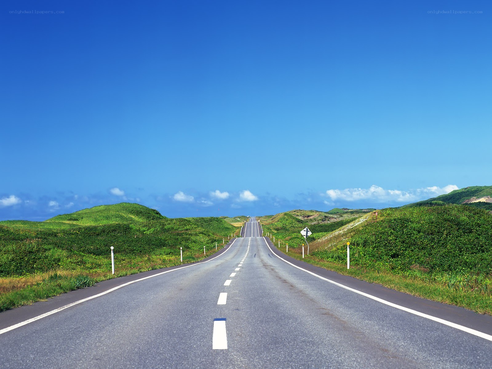 Long road through green hills