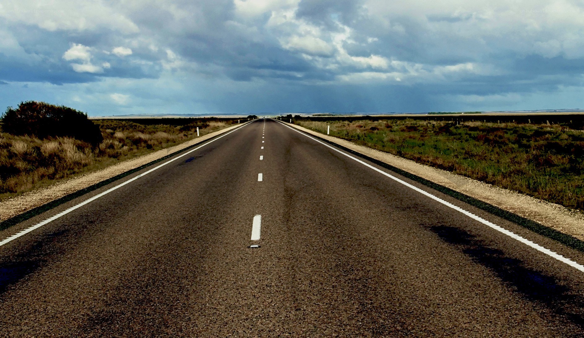 Long road under cloudy sky