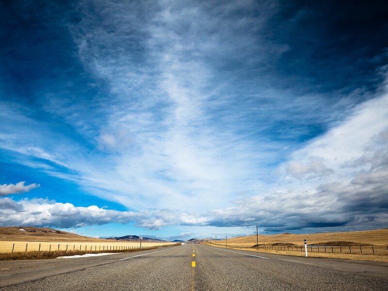 Long road under cloudy sky