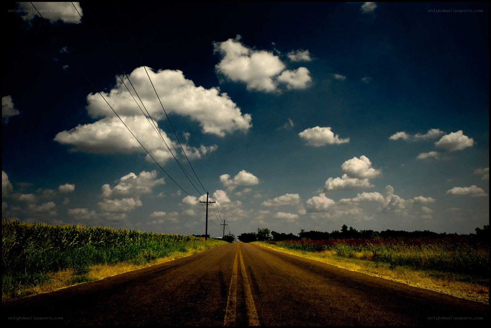 Long road under cloudy sky