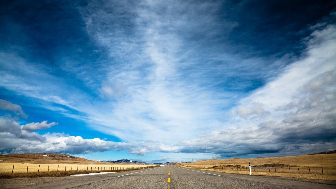 Long road under cloudy sky