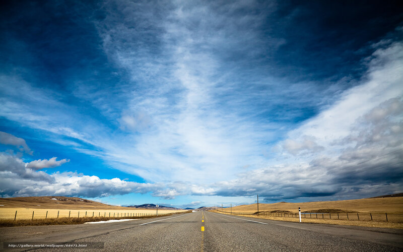 Long road under cloudy sky