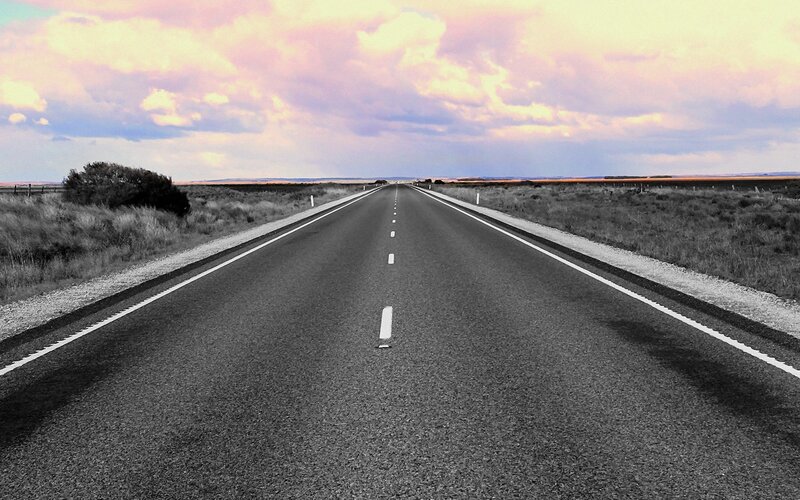 long road under colorful sky