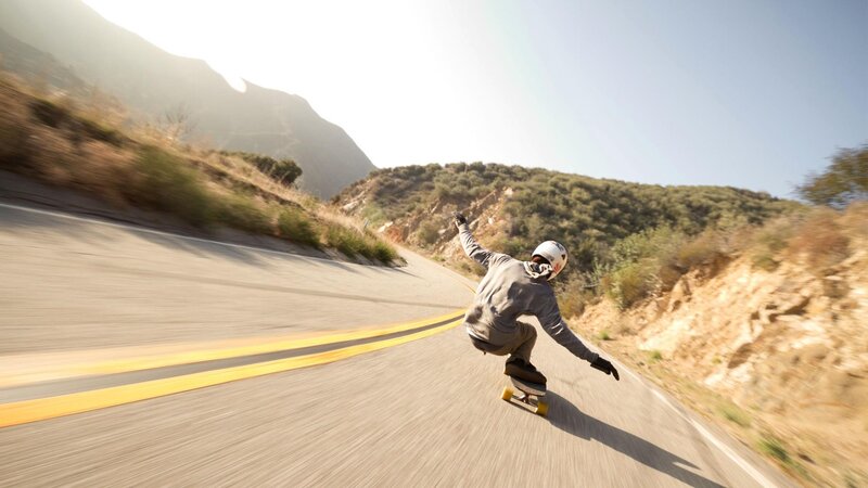 longboarder on mountain road