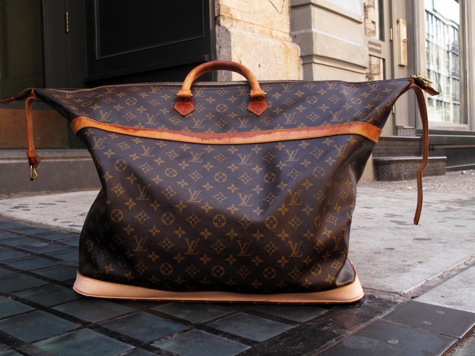 Louis Vuitton travel bag on sidewalk