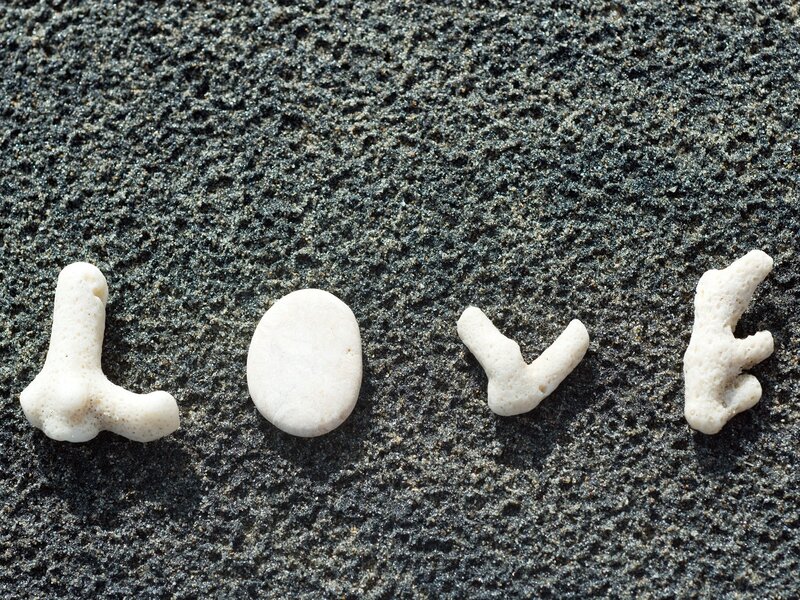 Love spelled with stones on sand