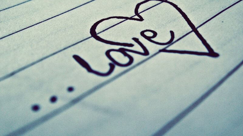 Love written in a heart on lined paper