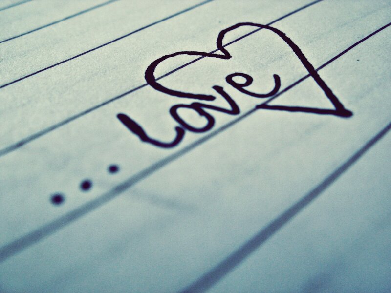 Love written in a heart on lined paper