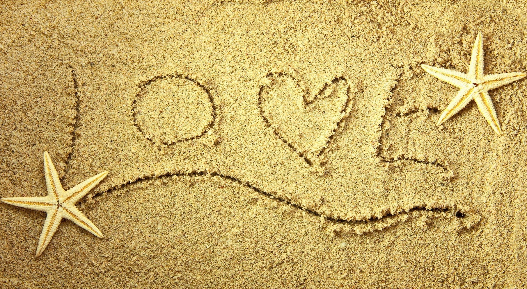 love written in sand with starfish