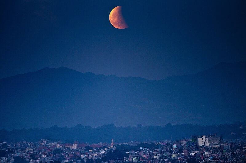 Lunar eclipse over city