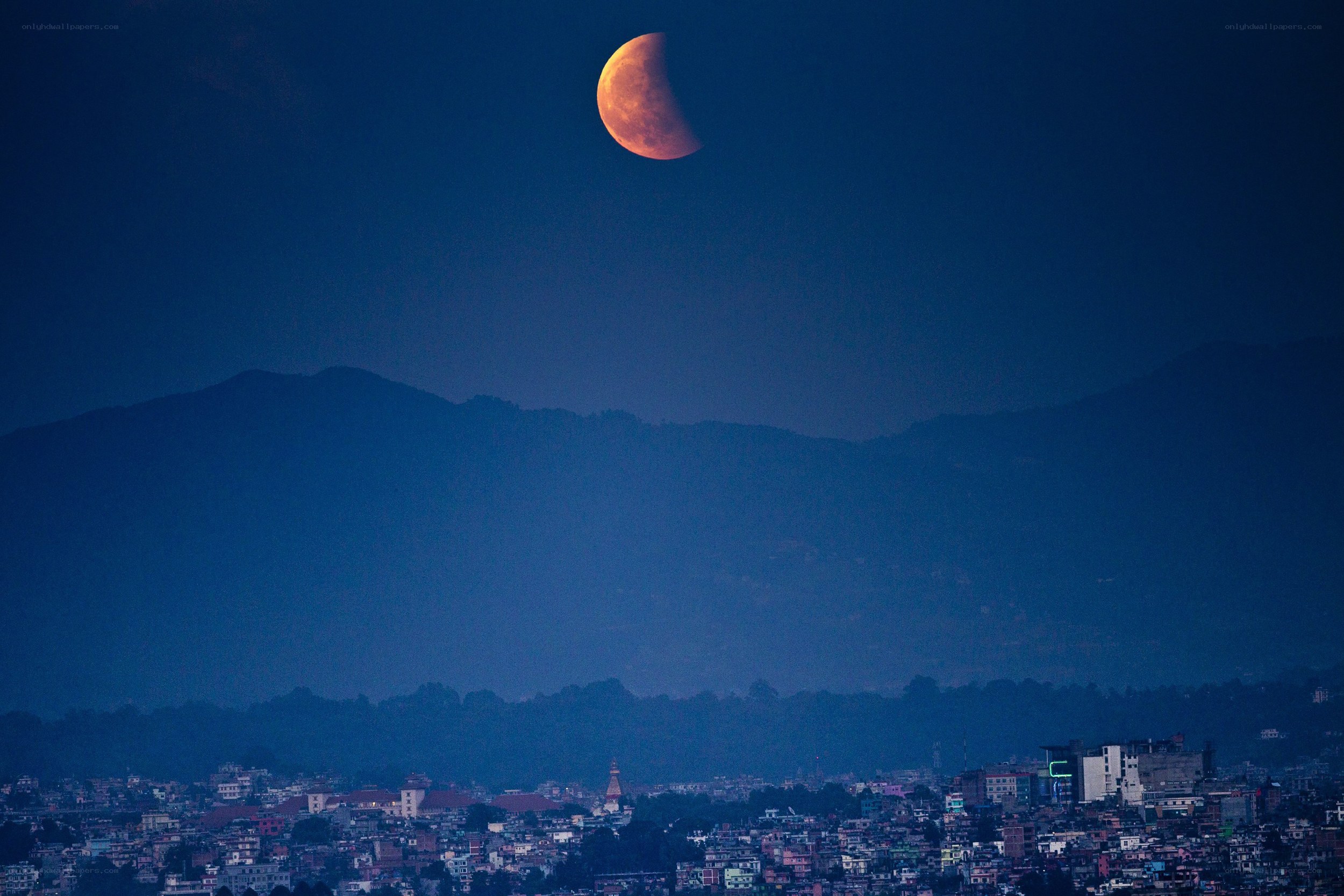 Lunar eclipse over city