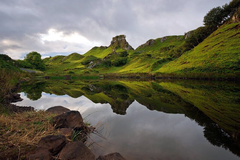 Lush green hills reflected in a calm lake