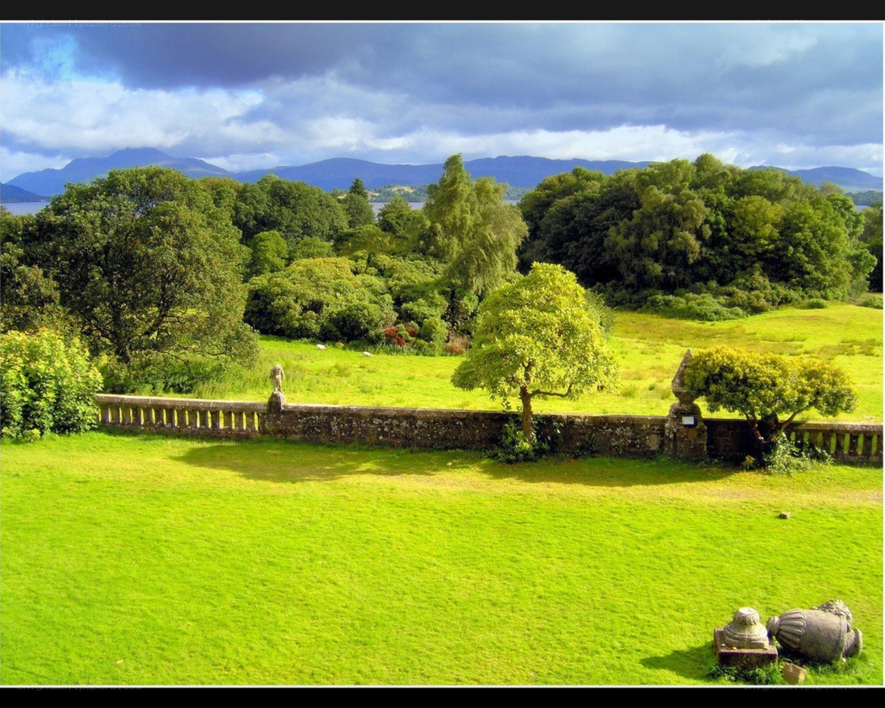 Lush green landscape with stone wall