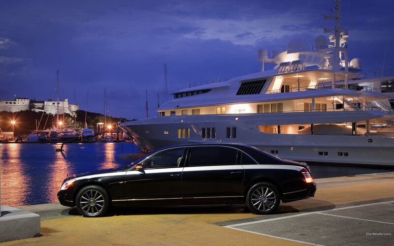 Luxury car and yacht at dusk