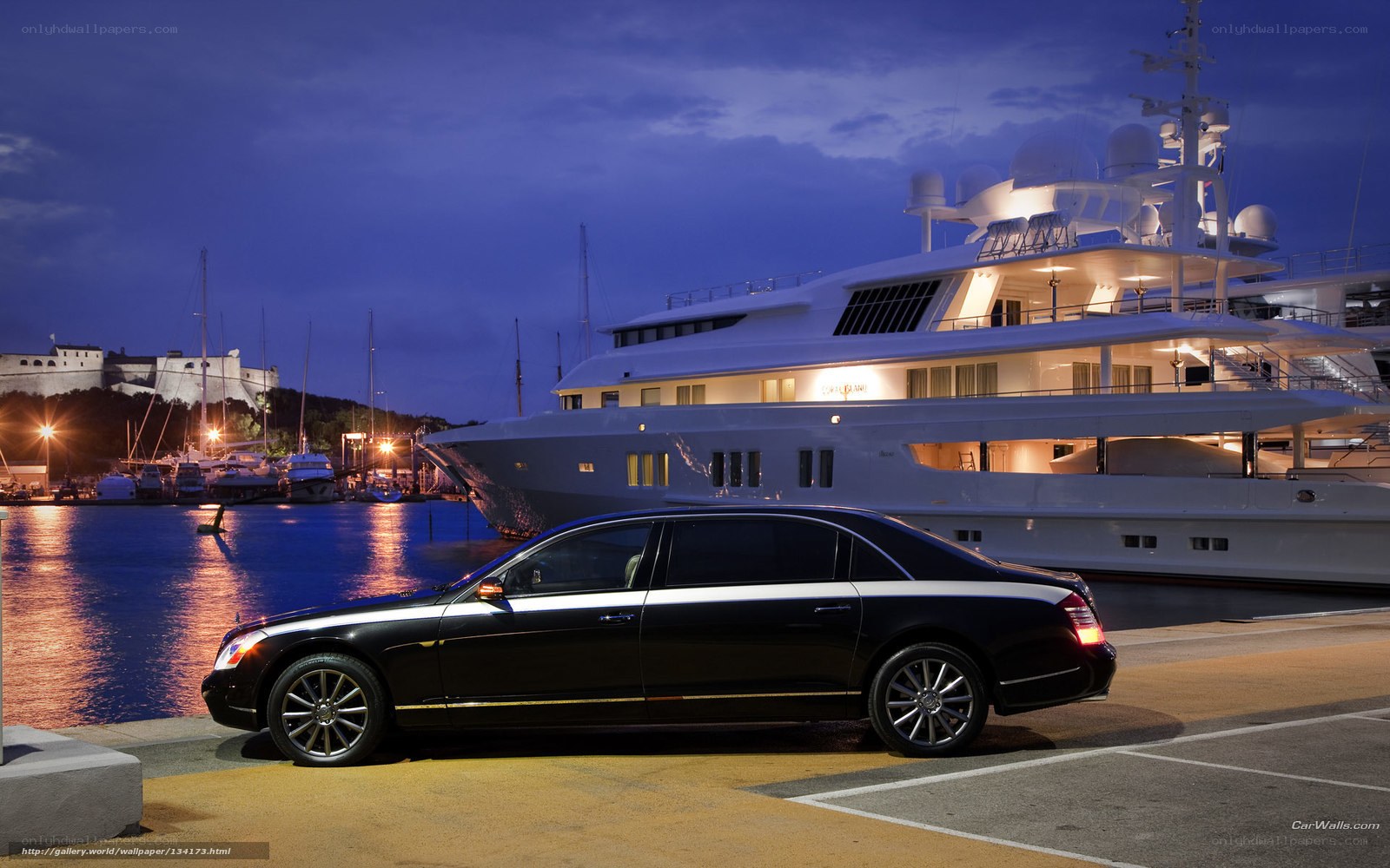 Luxury car and yacht at dusk
