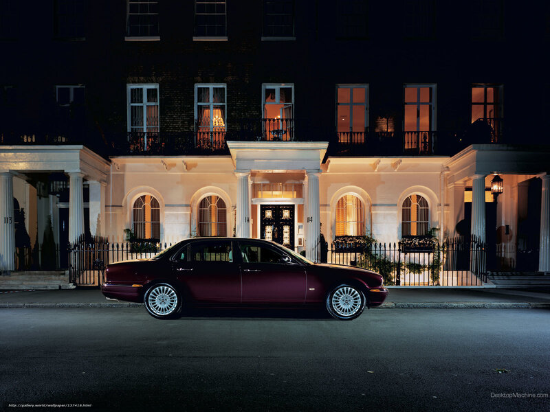 Luxury car at night in front of townhouse