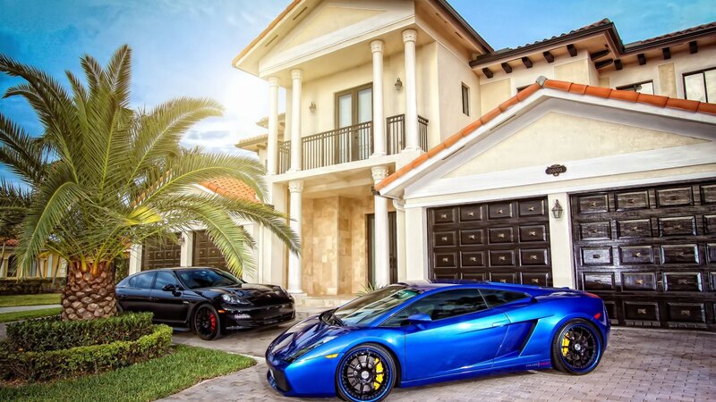 Luxury cars in front of a mansion