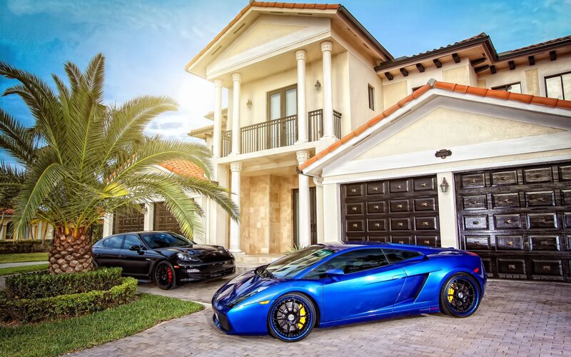 Luxury cars in front of a mansion