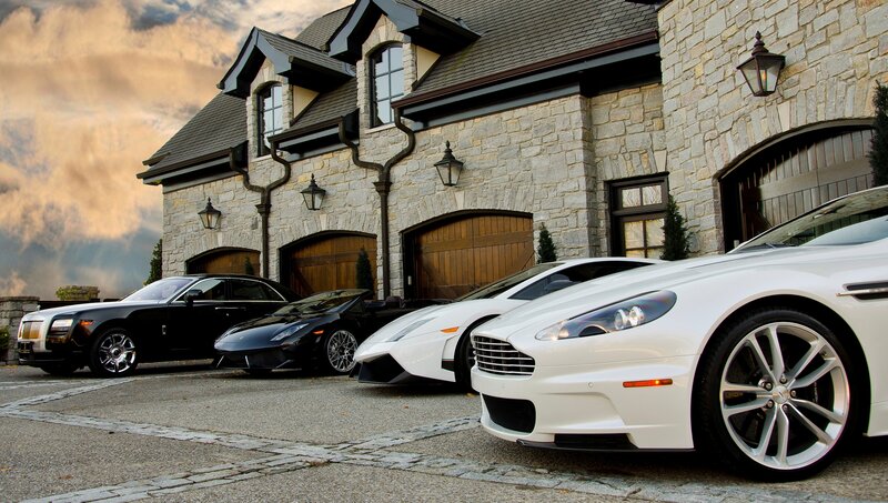 Luxury cars in front of stone house