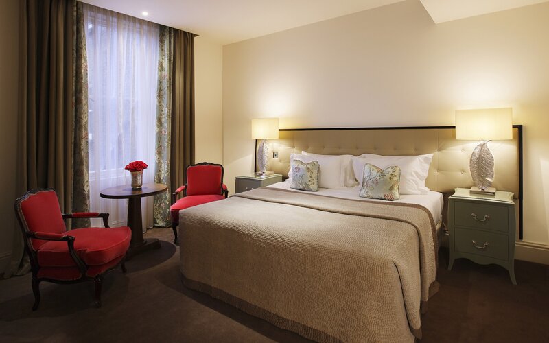 Luxury hotel bedroom with red chairs