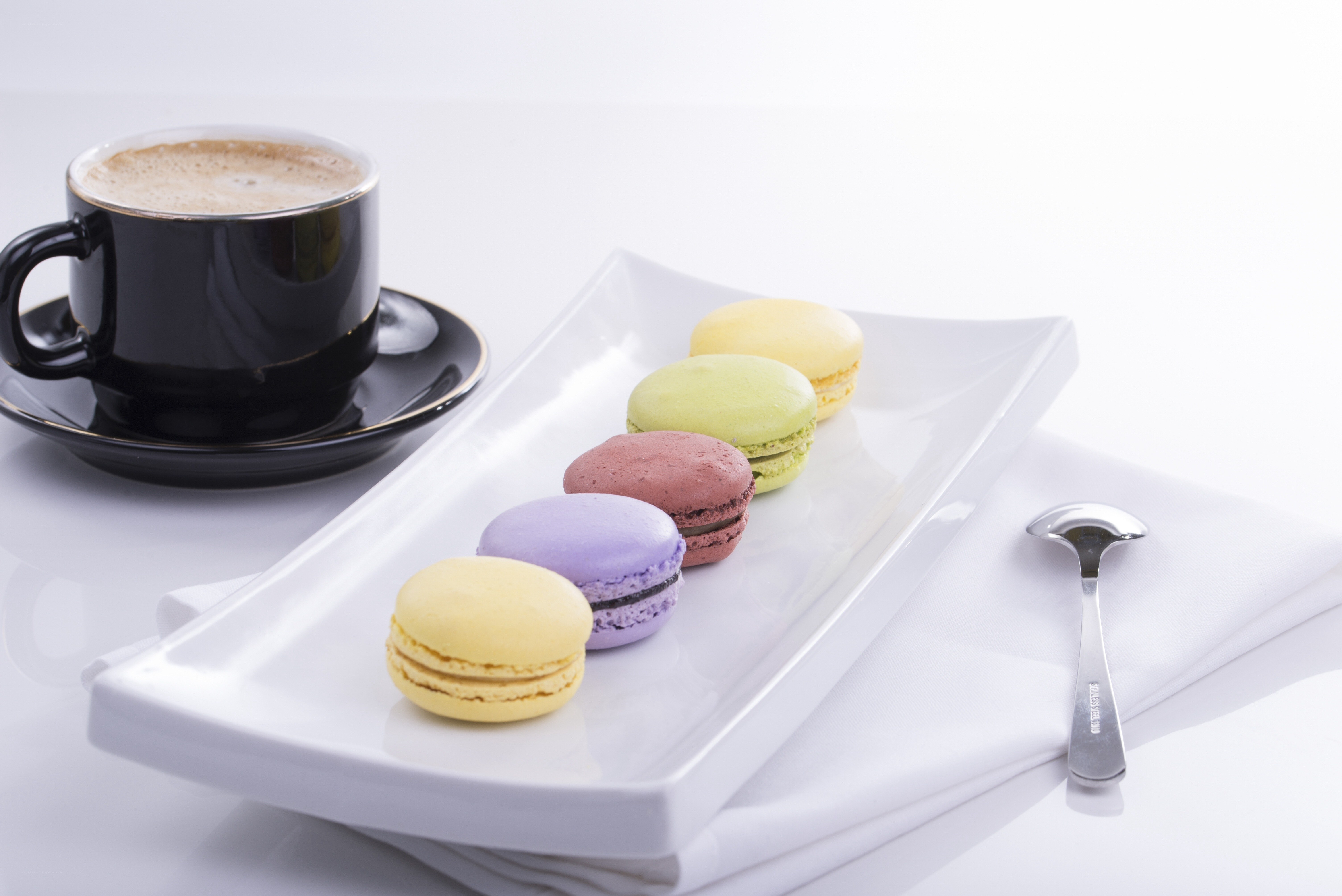 Macarons and coffee on white