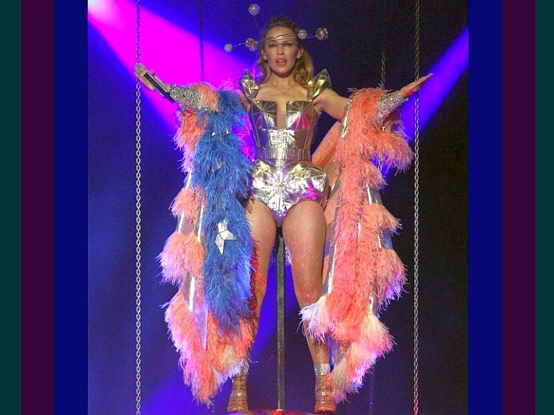 Madonna on stage in feathered costume