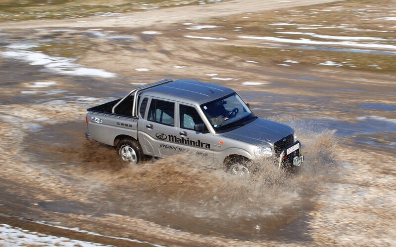 Mahindra pickup truck driving through mud