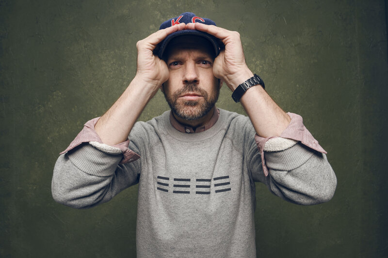 man adjusting cap on head