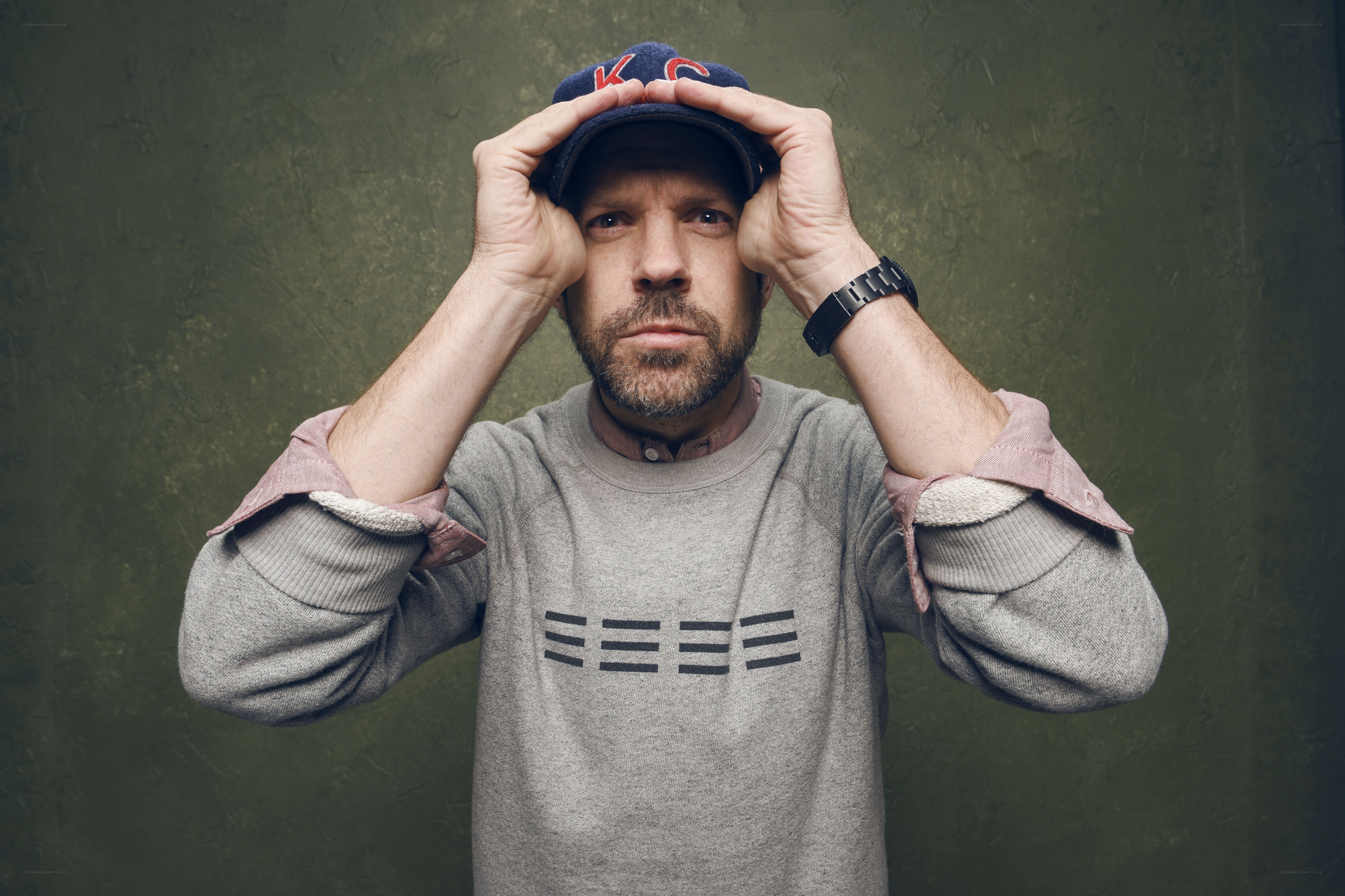 man adjusting cap on head