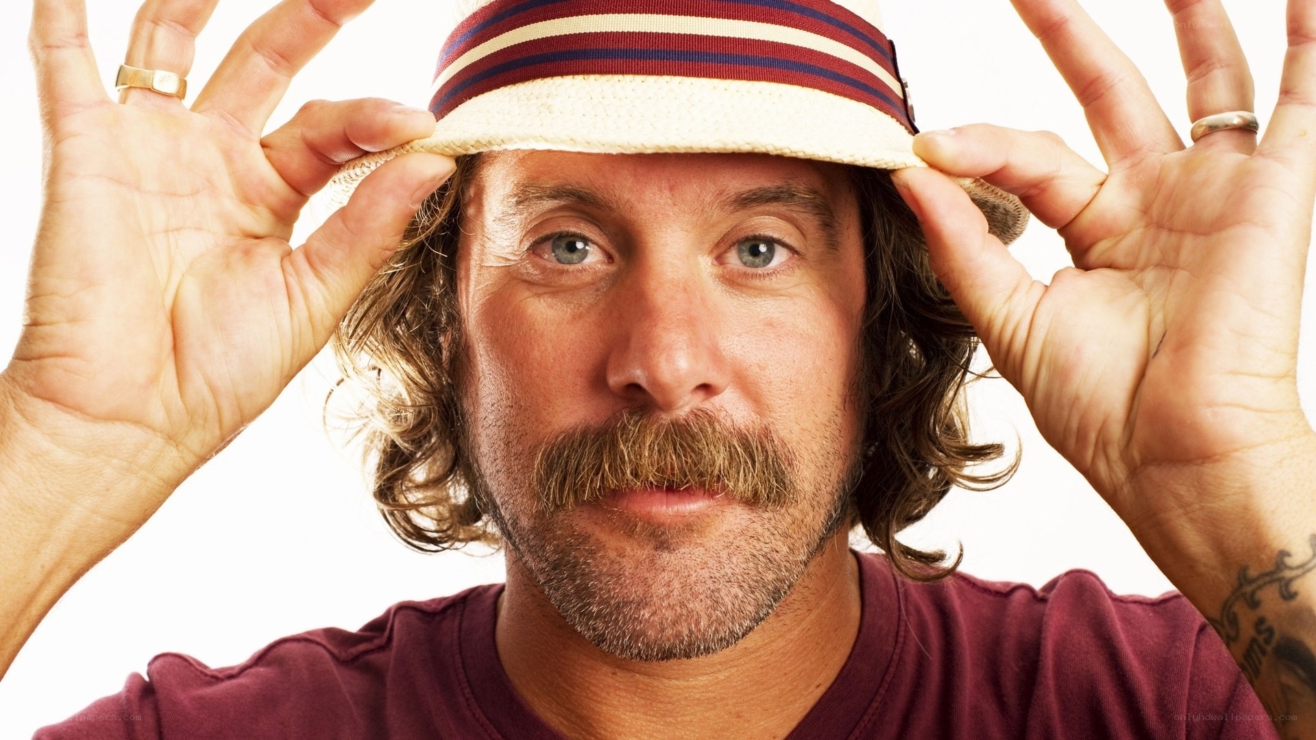 man adjusting hat with hands