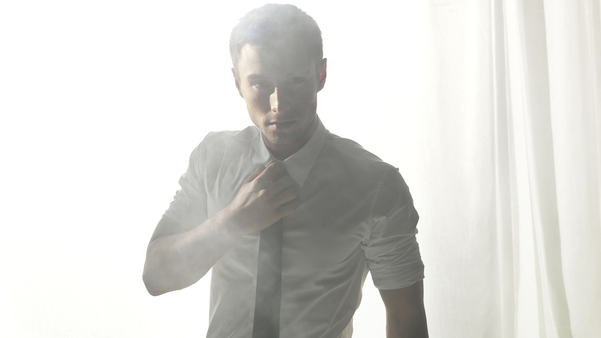 man adjusting his tie