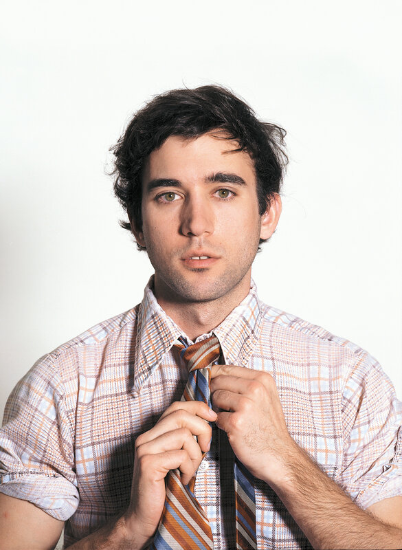 man adjusting his tie