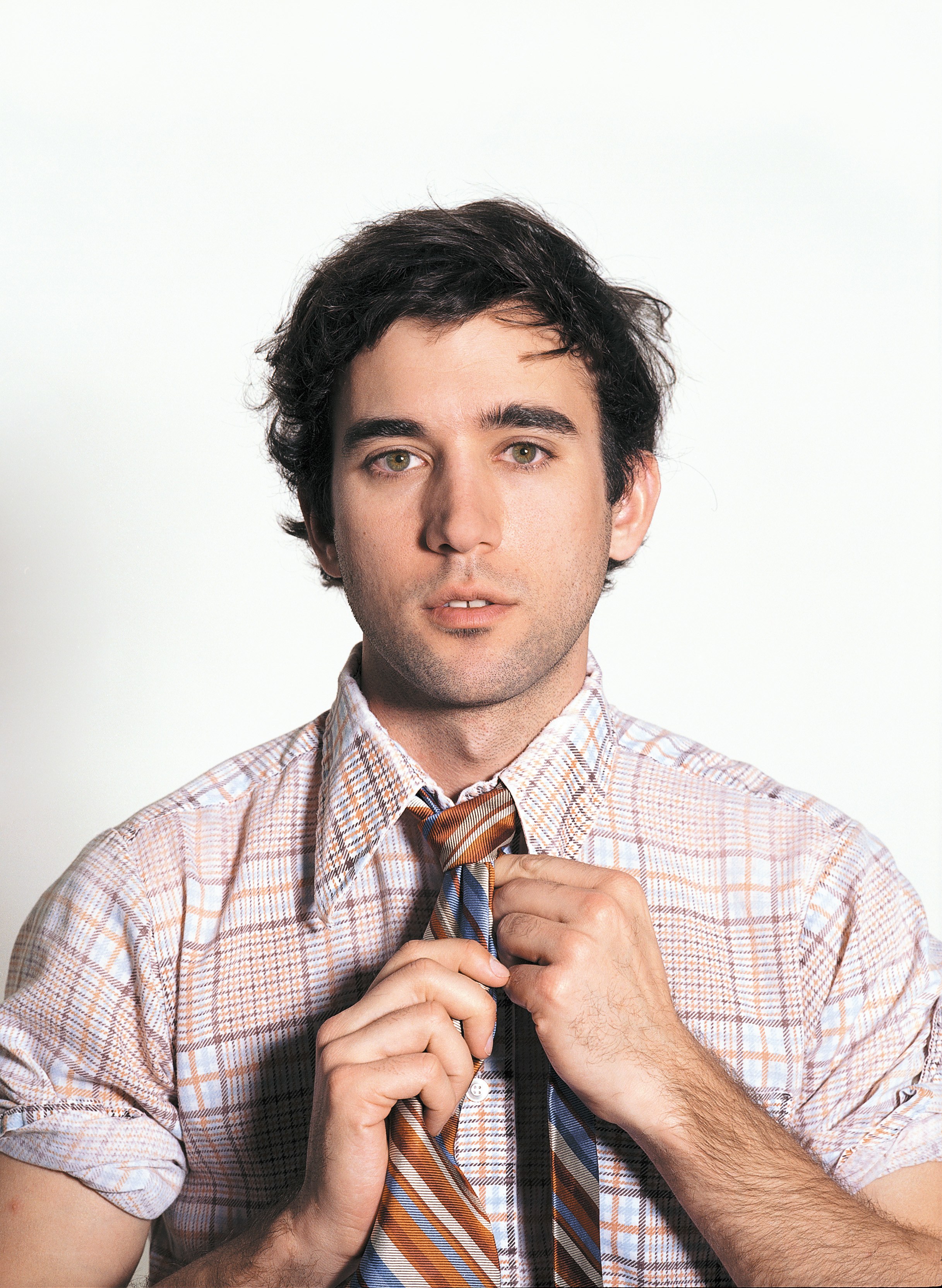man adjusting his tie