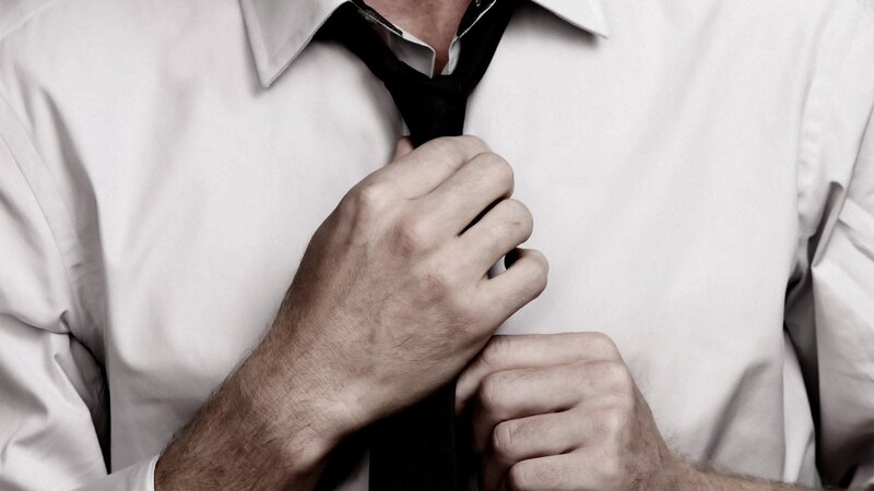 man adjusting his tie